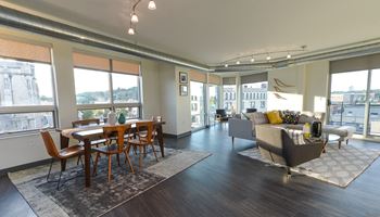 an open living room and dining room with a view of the city